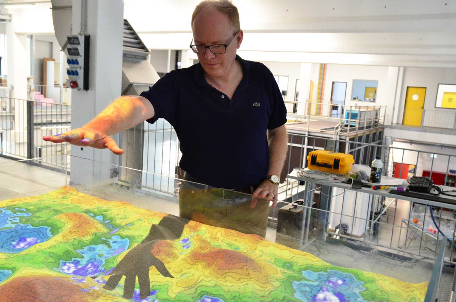 Prof. Dr. Helmut Grüning lässt es virtuell regnen. Die „Augmented Reality Sand Box“ gehört zum neusten Lehr-Equipment des Technikums für Hydraulik und Stadthydrologie. (Foto: FH Münster/Katharina Kipp) 