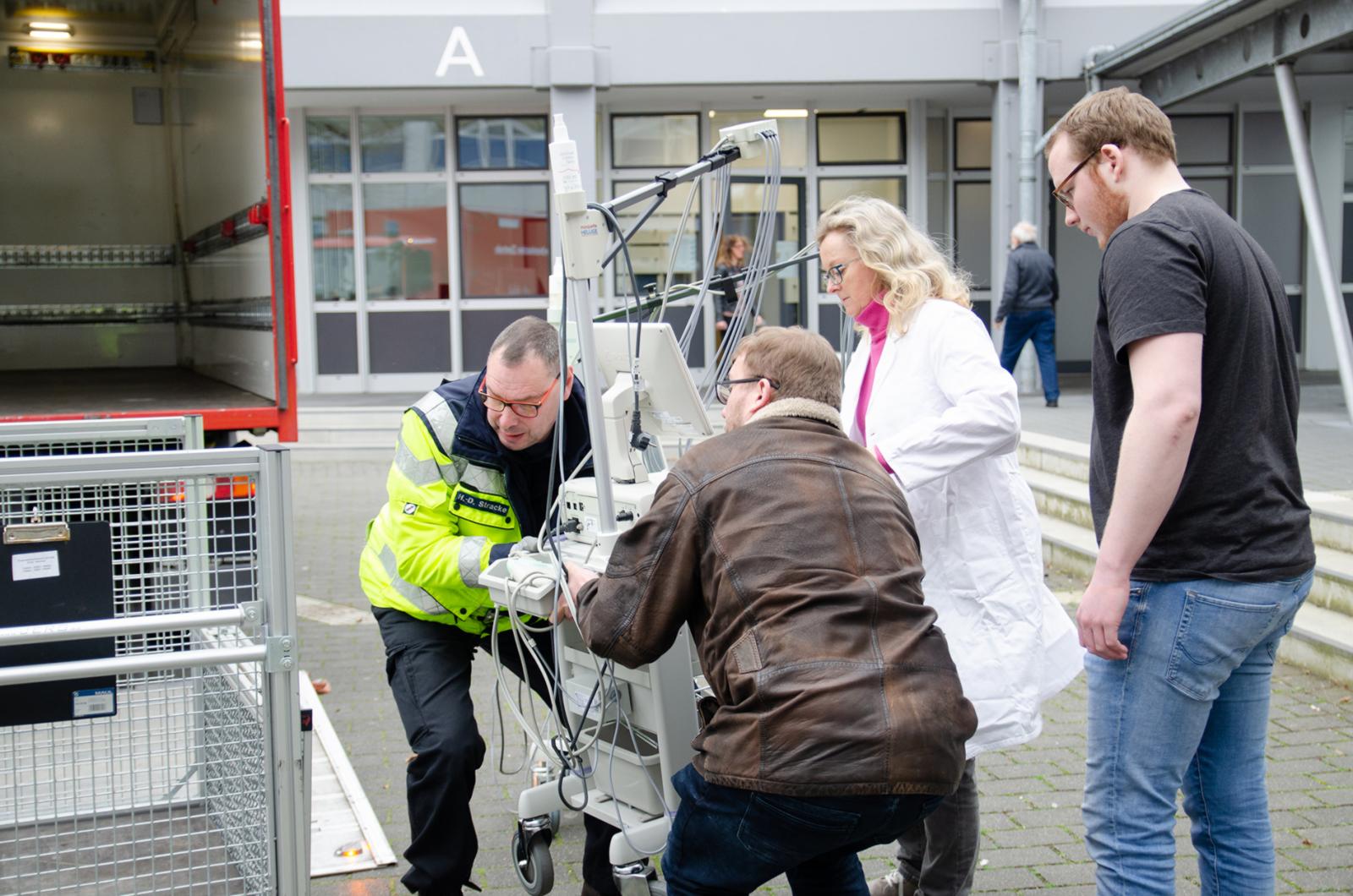 Prof. Dr. Karin Mittmann hilft beim Einladen der EKG-Geräte auf dem Steinfurter Campus. (Foto: FH Münster/Theresa Gerks) 